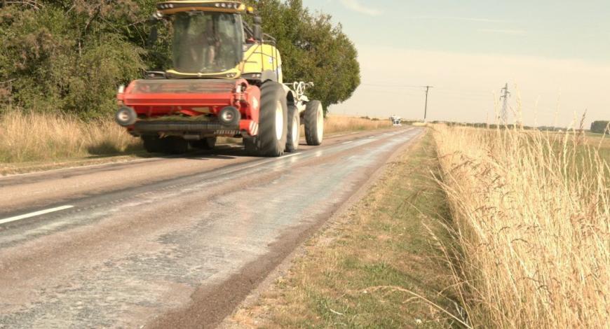 Un tracteur équipé d'un épandeur traite une route départementale de l'Aube au lait de chaux