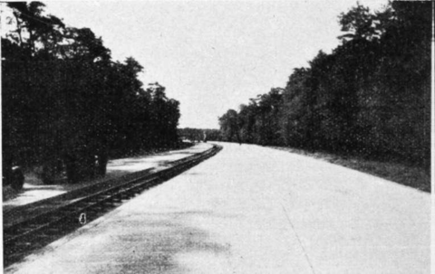Construction d’une autoroute allemande. Le terre-plein axial destiné à recevoir les plantations sert provisoirement à la circulation d’un chemin de for de service entre les deux chaussées bétonnées