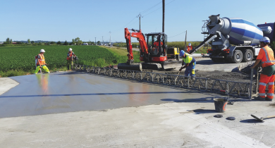 Le giratoire de Pérouges, sur la RD 65b, lors du bétonnage. La société Agilis a utilisé une règle vibrante pour assurer la mise en place du béton.