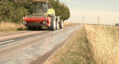 Un tracteur équipé d'un épandeur traite une route départementale de l'Aube au lait de chaux